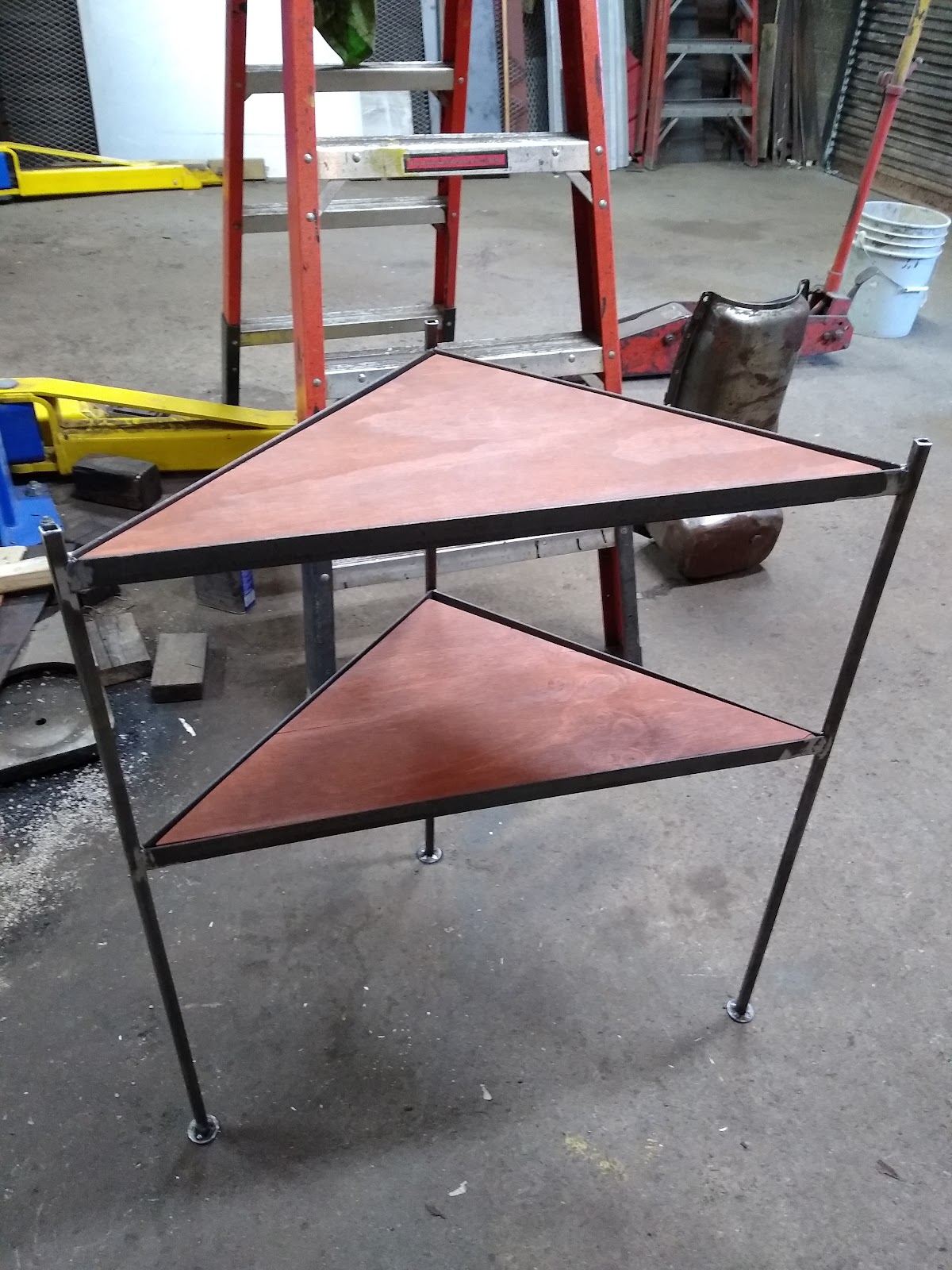 Custom two-tier welded side table with triangular wood shelves, built in the shop